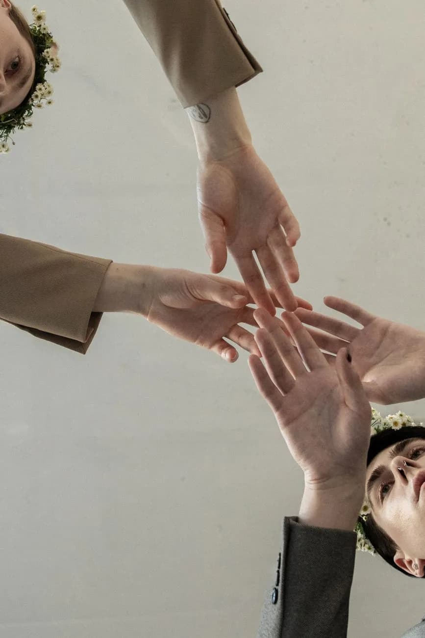 Fire ulike hender som rekker ut, som symboliserer enhet og tilknytning i en kunstnerisk komposisjon.